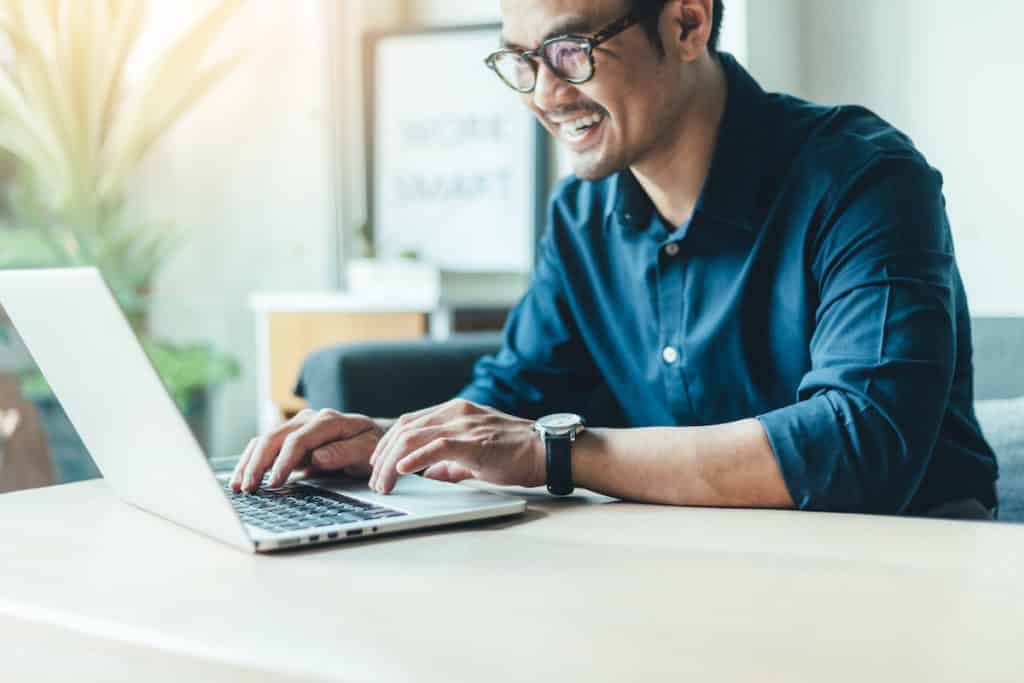 Man smiling while using computer