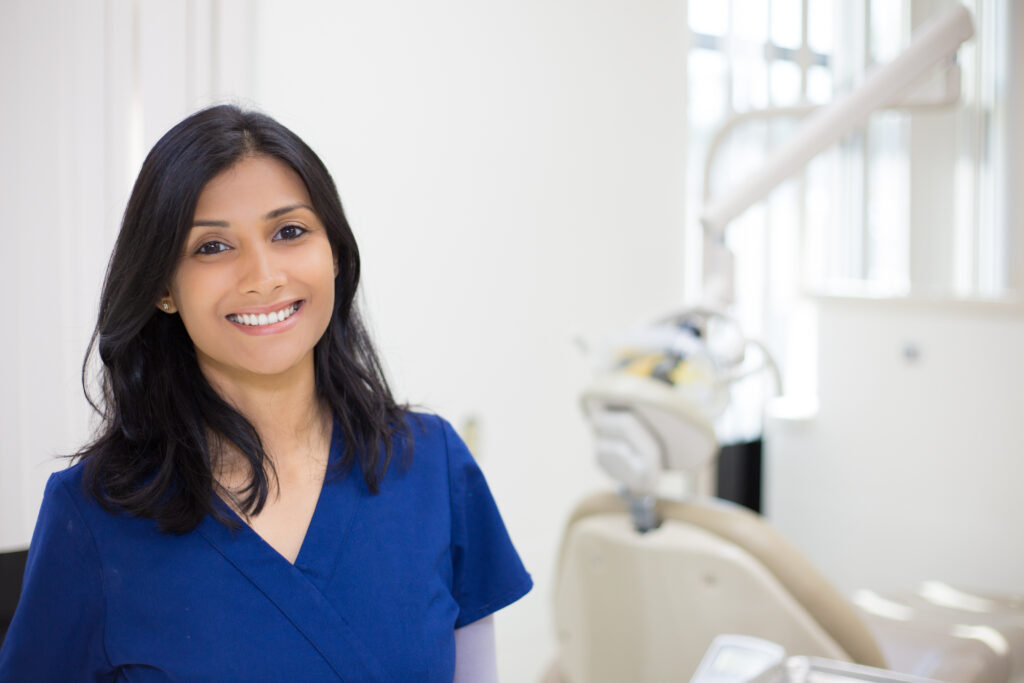 Closeup headshot portrait of friendly, cheerful, smiling confident female, healthcare professional in blue scrubs. isolated clinic hospital background. Patient visit